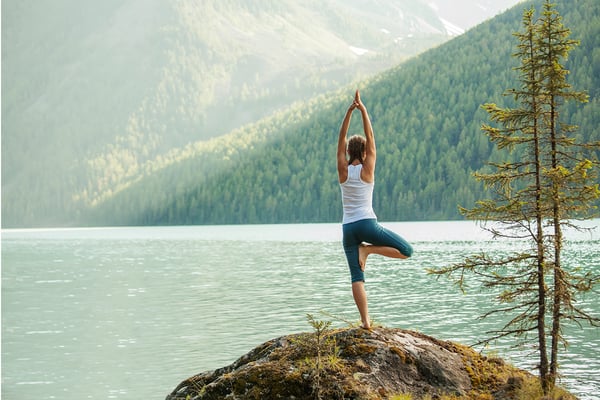 yoga instructor posing in front of lake