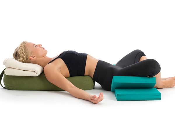 woman doing restorative yoga on foam pads