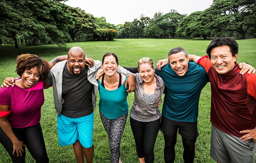 a diverse group of smiling fitness trainers all posing for picture