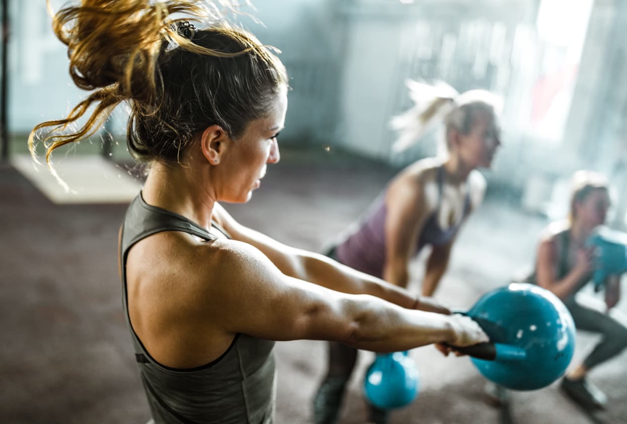 group fitness instructor building muscle with kettlebell